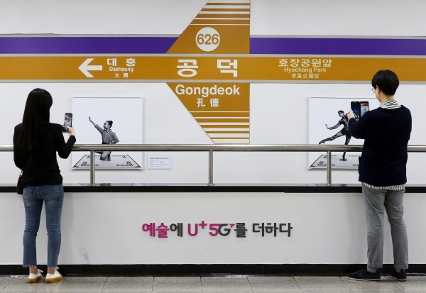 사진은 서울 지하철 6호선 공덕역에 마련된 세계 최초 5G기반 문화예술 공간 ’U+5G 갤러리’에 방문한 고객이 ‘U+AR’ 앱으로 작품을 체험하고 감상하는 모습.