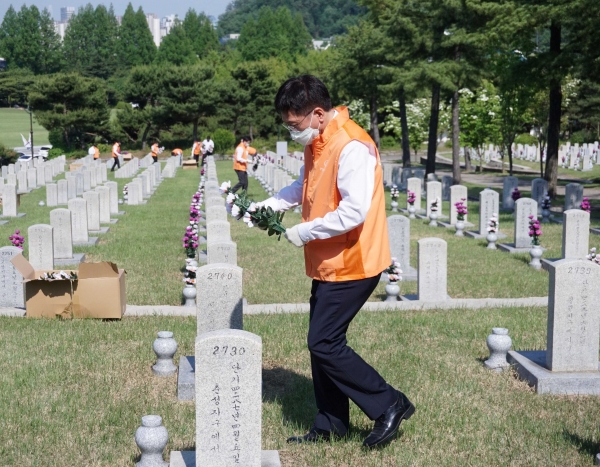 한화시스템 김연철 대표이사가 참배 후 묘역 정화 활동에 참여하고 있다.