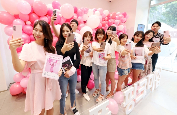 개통행사에 초청된 10명의 고객이 인스타그램에 올린 일상속 핑크빛 사진을 들고 기념촬영을 하고 있다.