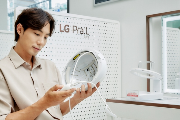 LG전자 모델이 서울 관악구 LG베스트샵 봉천점에 설치돼 있는 LG 프라엘 메디헤어 전용 체험공간에서 메디헤어를 착용해보고 있다.