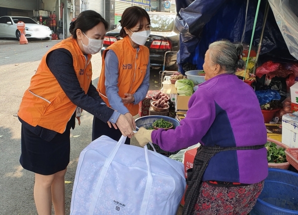 신협 임직원이 전통시장 소상공인들에게 난방용품을 전달하고 있다.