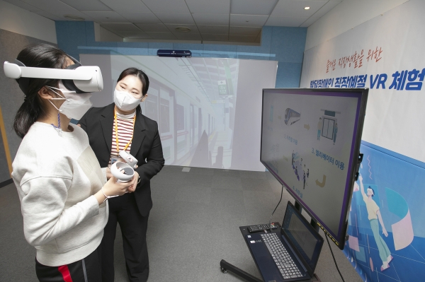 발달장애인이 VR기계를 쓰고 가상환경에서 직장생활을 체험하는 모습