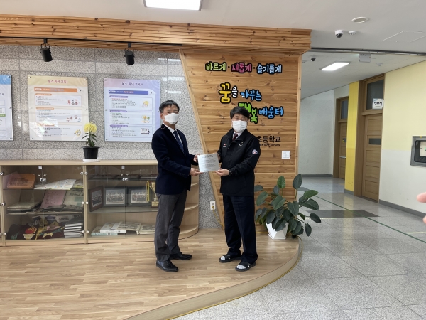 한국교통안전공단 조경수 기획본부장(왼쪽)과 김천 농소초등학교 어성천 교장(오른쪽)이 교실숲 현판 전달식 후 기념사진 촬영을 하고 있다
