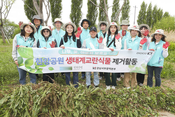 KT 임직원들이 생태계 교란 식물 제거 봉사활동을 마치고 기념 사진 촬영을 하고 있는 모습
